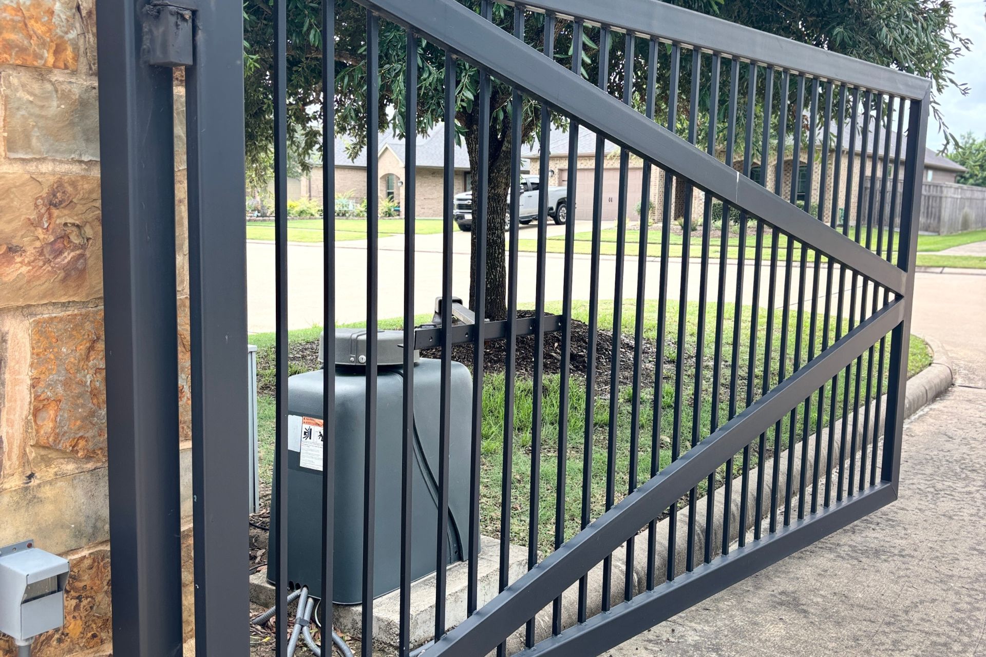 Custom steel fence and driveway gate installed at a residential property in Austin, TX