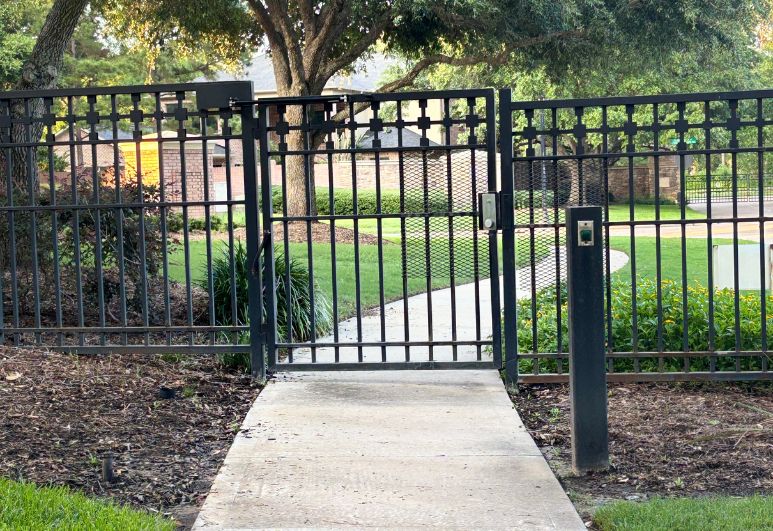 Custom steel perimeter fence and entry gate installed at a residential property in Austin, Texas featuring welded steel construction and secure property access.