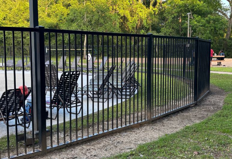 Custom steel pool safety fence installed around a residential swimming pool in Austin, Texas featuring code-compliant picket spacing and secure access gates.