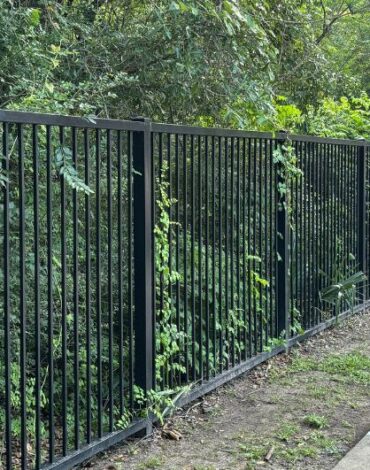 Custom steel privacy fence installed around a residential property in Austin, Texas.