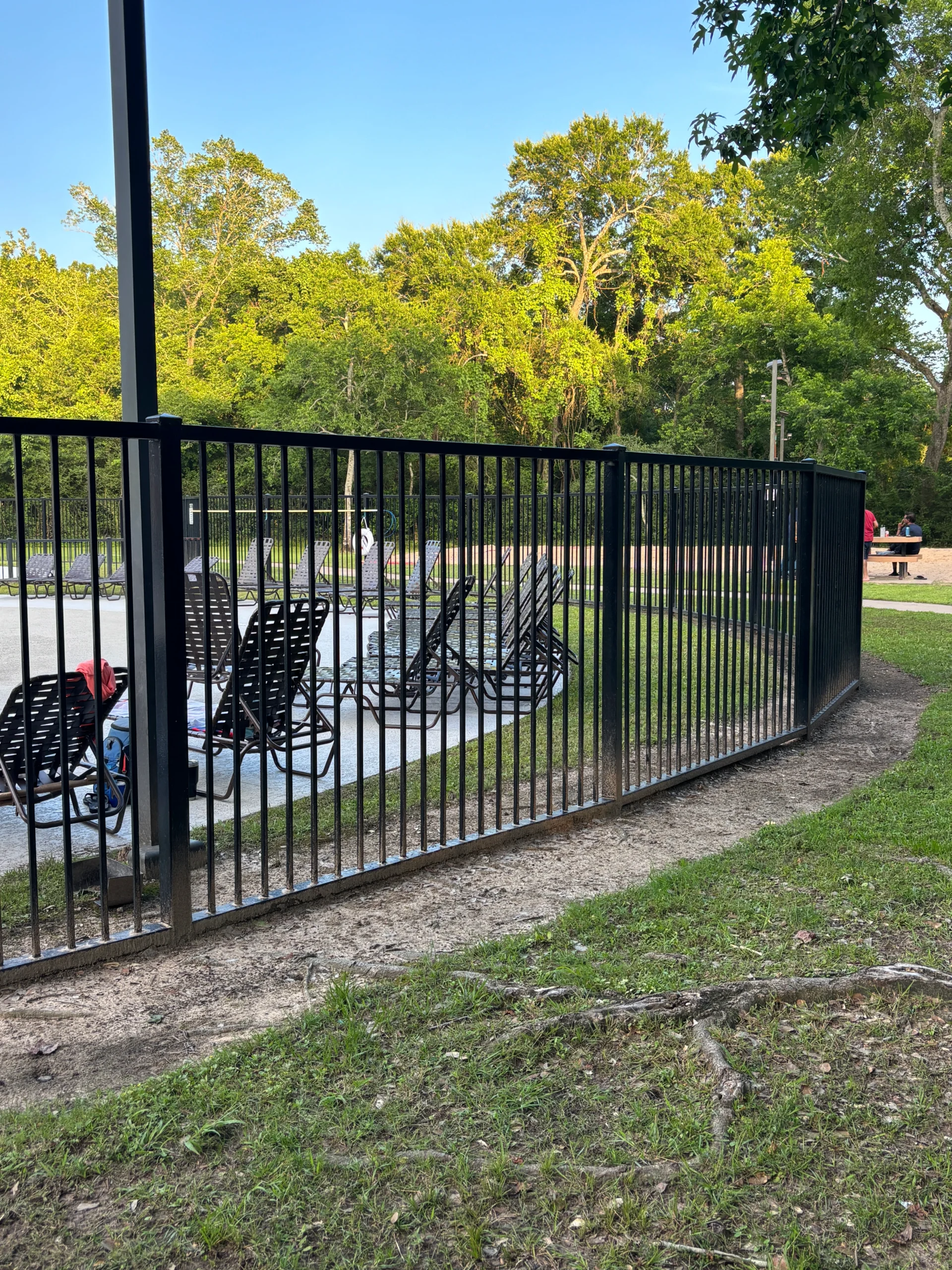 Steel fence installation showing black steel posts and panels being installed in a residential yard